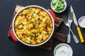 Potatoes and vegetables tortilla on a dark background, top view. Potatoes, green beans, bell peppers, green peas, cheese, eggs cas Royalty Free Stock Photo