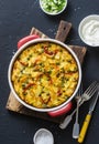 Potatoes and vegetables tortilla on a dark background, top view. Potatoes, green beans, bell peppers, green peas, cheese, eggs cas