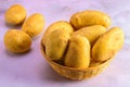 Fresh potatoes in a wicker basket on a light marble. Royalty Free Stock Photo