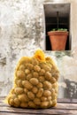 Potatoes in the yellow net products vegetables young , against an old grey wall background