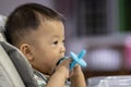 Potrait image of adorble and cute happy Asian Chinese baby boy sit on baby chair playing toy