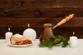 Pots of coffee, fir twig, apple pie, cinnamon sticks and candles on the wooden background