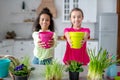 Two cute teens showing pots with flowers