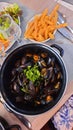pots overflowing with freshly cooked mussels with french fries
