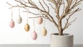 A potted tree with Easter eggs hanging from its branches in a modern minimalist setting Royalty Free Stock Photo