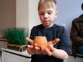 Potter boy proudly holding a clay pot