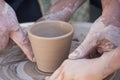 A potter craftsman transfers his skills to a student