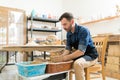 Potter Creating Creative Pottery While Sitting In Workshop