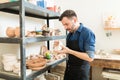 Potter Examining Clay Bowl While Working In Studio Royalty Free Stock Photo