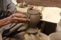 Potter hands making in clay on pottery wheel.