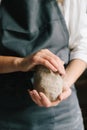 Potter holds a piece of wet clay in their hands, molds it into form. Process of creating ceramic products.