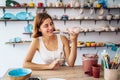 Potter looking at handmade mug, produced in own workshop. Woman examining clay itmes for sale. Meticulously checking for defects, Royalty Free Stock Photo