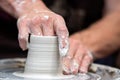 Potter makes pottery dishes on potter`s wheel