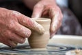 Potter makes pottery dishes on potter`s wheel