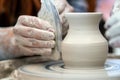 Potter makes pottery dishes on potter`s wheel