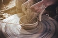 Potter makes on the pottery wheel clay pot.