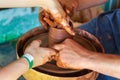 Potter makes on the pottery wheel clay pot and conducts a master class. Hands of the master and child close-up during work.