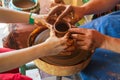 Potter makes on the pottery wheel clay pot and conducts a master class. Hands of the master and child close up during work