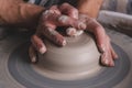 Potter making a new product of white clay on the potter`s wheel circle in studio, concept of creativity and art, horizontal photo