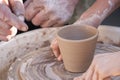 A potter craftsman transfers his skills to a student