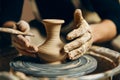 Potter modeling ceramic pot from clay on a potter`s wheel