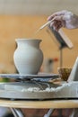 the Potter molds a pot from clay on a Potter's wheel. The master's hands make a pot on the potter's wheel. vertical photo Royalty Free Stock Photo