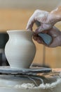 the Potter molds a pot from clay on a Potter's wheel. The master's hands make a pot on the potter's wheel. vertical photo Royalty Free Stock Photo