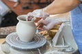 the Potter molds a pot from clay on a Potter's wheel. The master's hands make a pot on the potter's wheel. Royalty Free Stock Photo