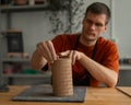 Potter sculpts a patterned cylinder from clay. Royalty Free Stock Photo