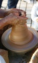 A potter teaches a chid how to makw a clay jar