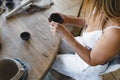 A potter woman sculpts clay at a table. Top view.