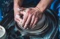 Potter at work on a pottery wheel with white clay. Hands of the master. Royalty Free Stock Photo