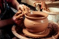 Potter at work. Workshop. Hands of a potter, creating an earthen jar on the circle Royalty Free Stock Photo