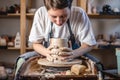 Potter working on a Potter`s wheel making a vase. Young woman forming the clay with hands creating jug in a workshop Royalty Free Stock Photo