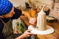 Potter working on potter`s wheel with raw clay with hands, making new bowl Royalty Free Stock Photo