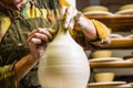 Potter working on potter`s wheel with raw clay with hands, making new bowl Royalty Free Stock Photo