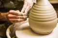 Potter working on potter`s wheel with raw clay with hands, making new bowl Royalty Free Stock Photo