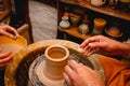 Potter working on potters wheel with clay. Process of making ceramic tableware in pottery workshop Royalty Free Stock Photo