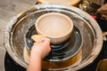 Potter working on potters wheel with clay. Process of making ceramic tableware in pottery workshop Royalty Free Stock Photo