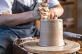 Potter working on a Potter`s wheel making a vase. Woman forming the clay with hands creating jug in a workshop. Close up Royalty Free Stock Photo