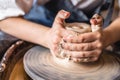 Potter working on a Potter`s wheel making a vase. Woman forming the clay with hands creating jug in a workshop. Close up Royalty Free Stock Photo