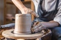 Potter working on a Potter`s wheel making a vase. Woman forming the clay with hands creating jug in a workshop. Close up Royalty Free Stock Photo