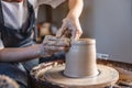 Potter working on a Potter`s wheel making a vase. Woman forming the clay with hands creating jug in a workshop. Close up Royalty Free Stock Photo