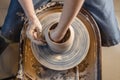 Potter working on a Potter`s wheel making a vase. Woman forming the clay with hands creating jug in a workshop. Top view Royalty Free Stock Photo