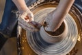 Potter working on a Potter`s wheel making a vase. Woman forming the clay with hands creating jug in a workshop. Top view Royalty Free Stock Photo