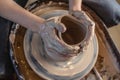 Potter working on a Potter`s wheel making a vase. Woman forming the clay with hands creating jug in a workshop. Top view Royalty Free Stock Photo