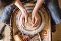 Potter working on a Potter`s wheel making a vase. Woman forming the clay with hands creating jug in a workshop. Top view Royalty Free Stock Photo