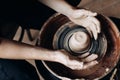 A potter works on a potter`s wheel in his workshop