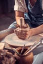 The potter works in the workshop. Hands and a potter& x27;s wheel close-up