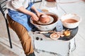 Pottery artist placing clay lump near bowl rim on wheel